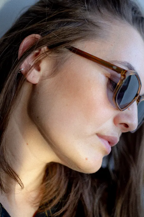 Seitliches Portrait einer Frau mit HUG Sonnenbrille in natürlichem Licht