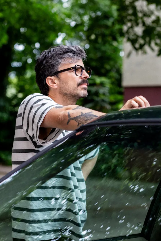 Mann mit HUG Brille im Outdoor-Portrait neben einem Auto