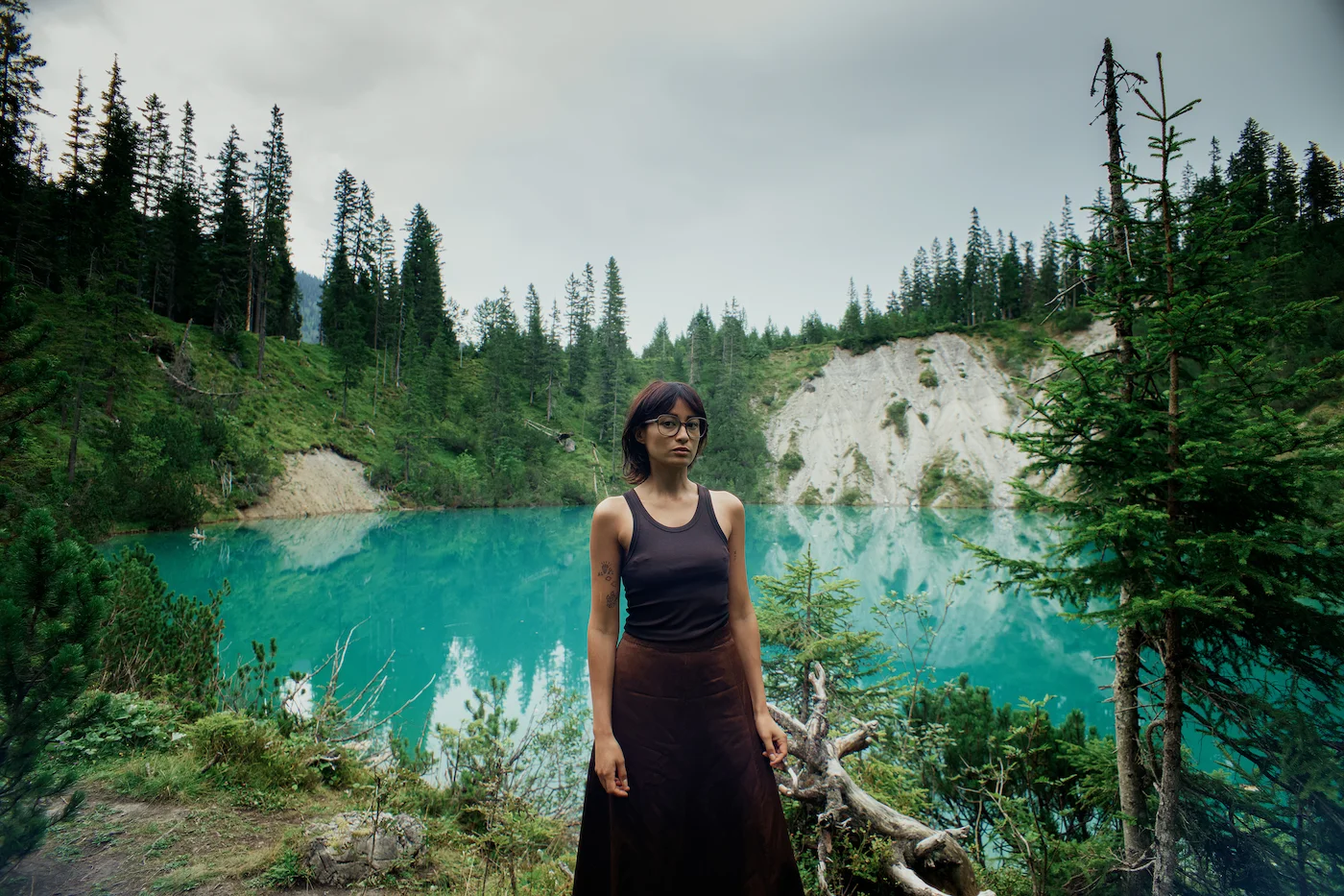 Frau mit ROLF Brillenfassung aus Naturmaterial vor Bergsee in ruhiger Landschaft – Optik Grote in Arnsberg