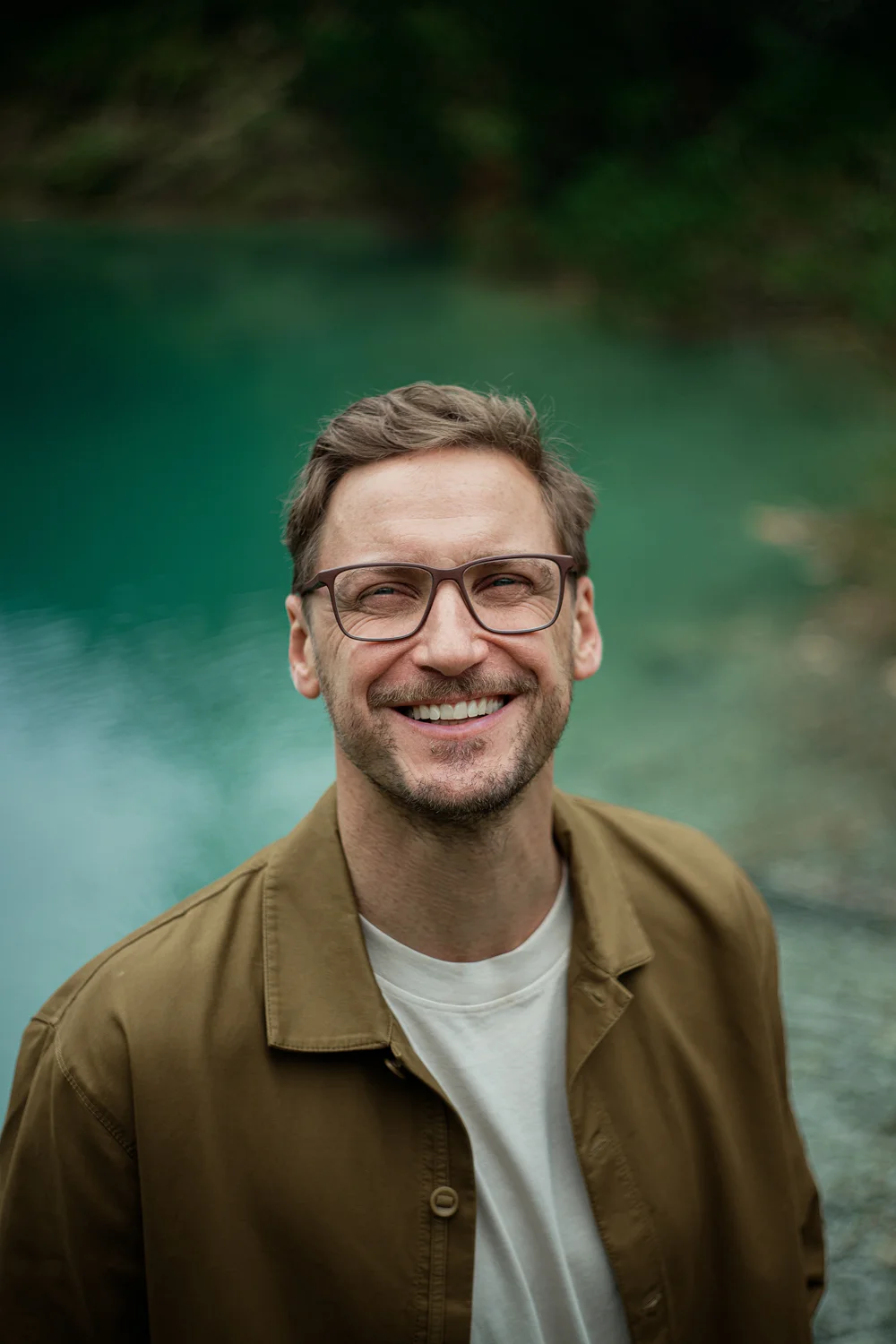 Mann mit ROLF Brillenfassung aus Naturmaterial vor ruhiger Landschaft – Optik Grote in Arnsberg